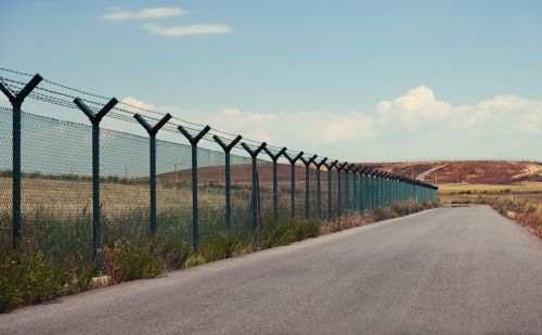 Road next to a fence in a clear day.